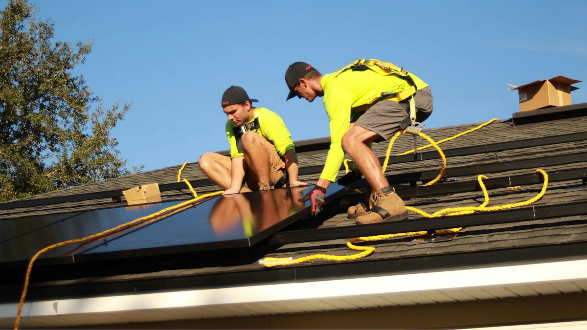Solar installation team fitting panels on a roof
